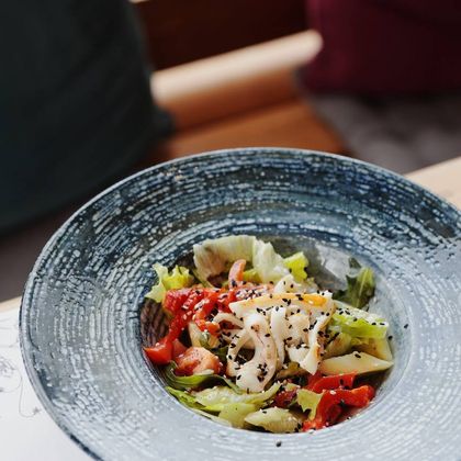 Салат с кальмаром, тайским соусом, чука салатом, пикантным соусом и кунжутом